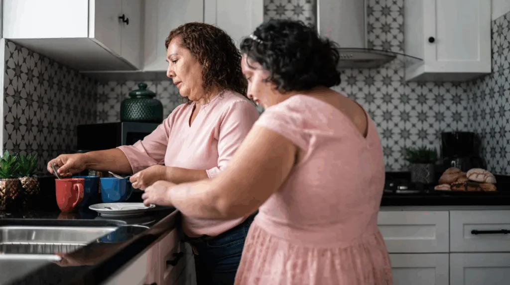 teen girl with Intellectual and Developmental Disabilities helping her caregiver in the kitchen a sign of improved social connections
