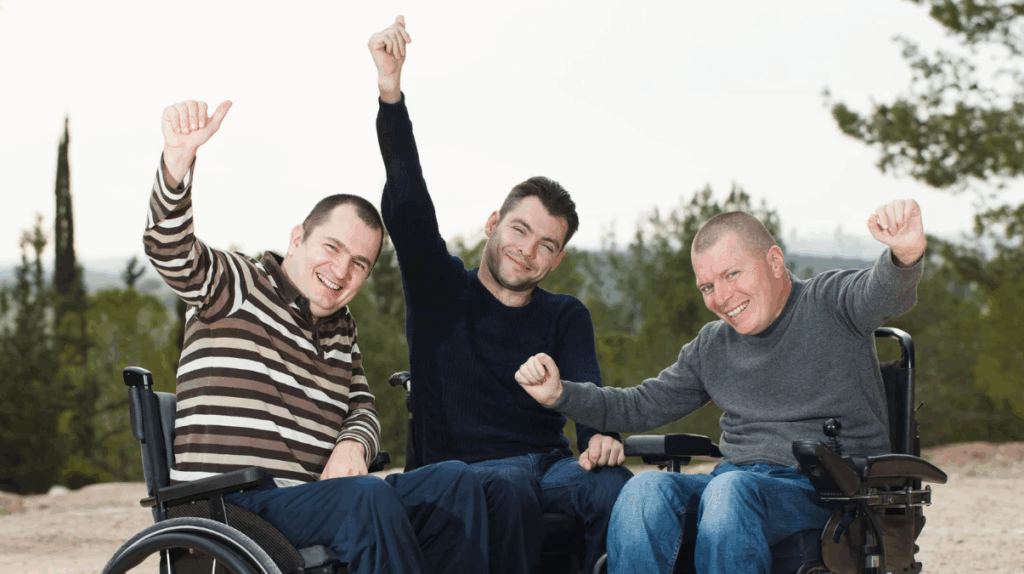 group of friends on a wheelchair raising their hands